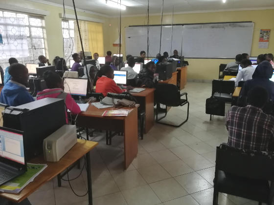 A classroom with students sitting in front of computer screens